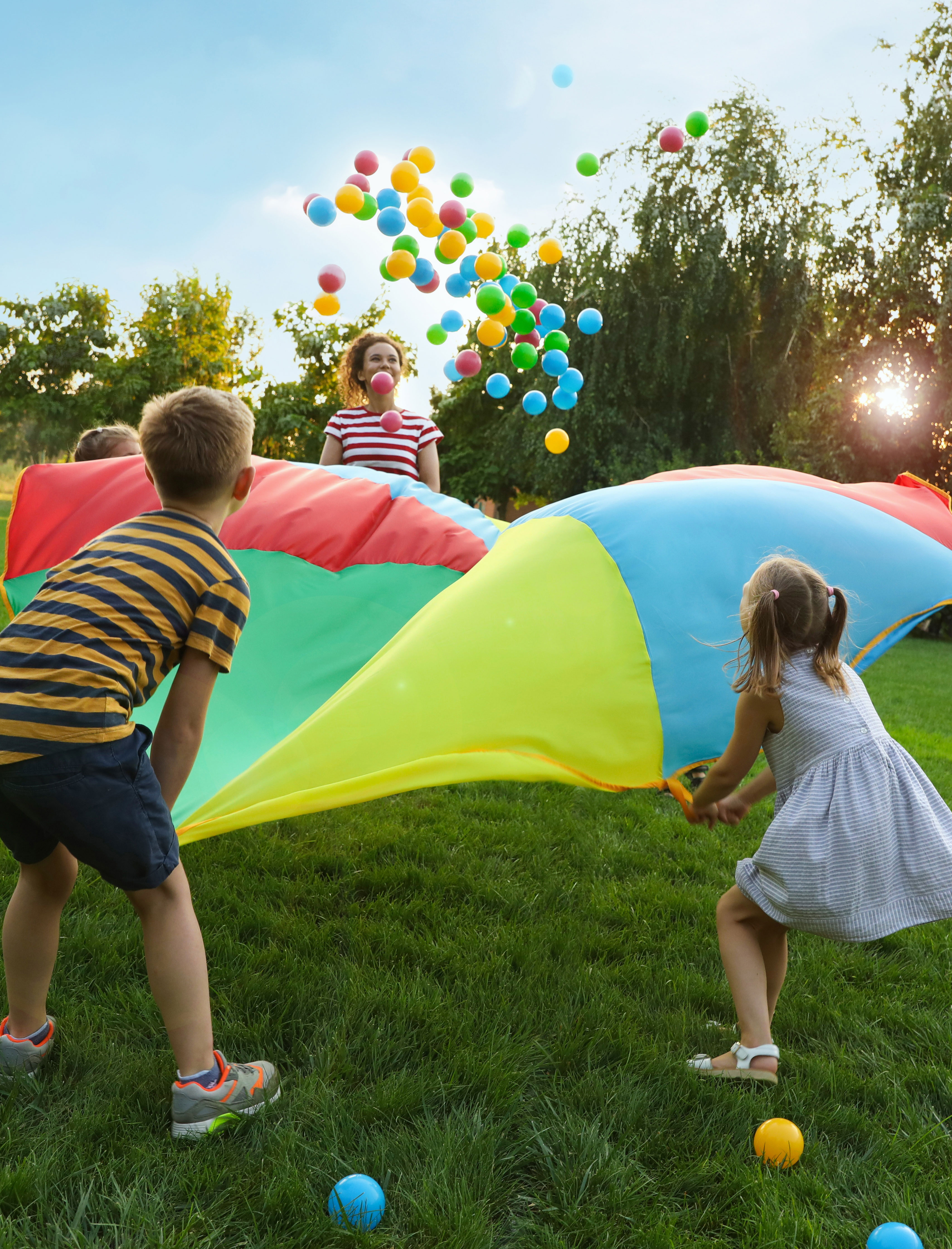 spielende-kinder-auf-wiese-mit-bällen-und-tuch-kiju-wildblume